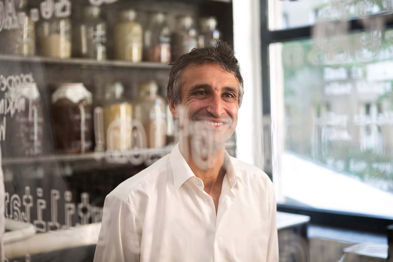 Natural photo of Manu Kumar in his shop through glass windows