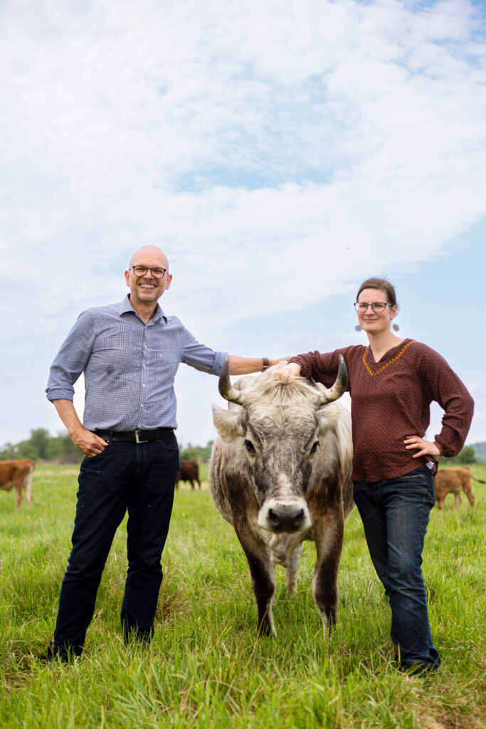 Portrait des Demeter Vorstands Alexander Gerber zusammen mit Bäuerin und Schriftstellerin Anja Hradetzky und Kühen auf einer Weide in Brandenburg. Entstanden für das Kundenmagazin Demeter Journal.